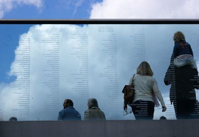 Rear view of friends against sky