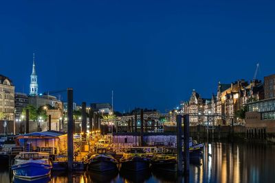 Buildings by river against sky