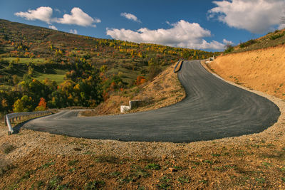 Road amidst land against sky