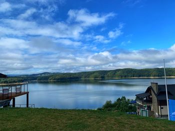 Scenic view of lake by buildings against sky