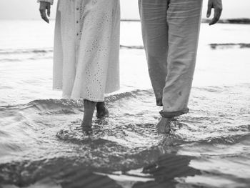 Low section of man standing in water