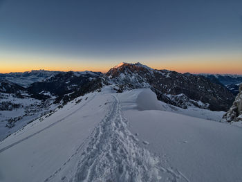 Scenic view of snow covered landscape against sky during sunset