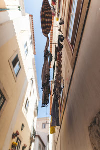 Low angle view of hanging amidst buildings in city