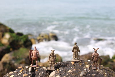 Close-up of chess pieces on rock in sea