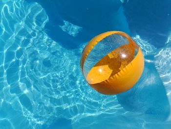 Directly above shot of yellow inflatable ball in swimming pool