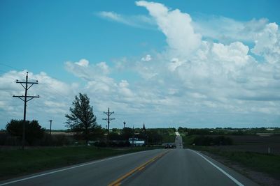 Country road against cloudy sky