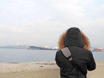 Rear view of woman looking at sea against sky