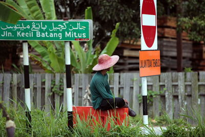 Man wearing hat by information signs