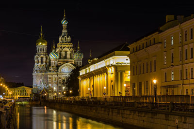 Illuminated buildings against sky at night