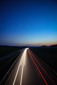 Empty road against clear sky at night