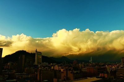 Buildings in town against cloudy sky