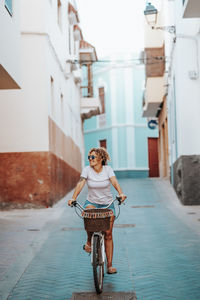 Rear view of woman with bicycle on street