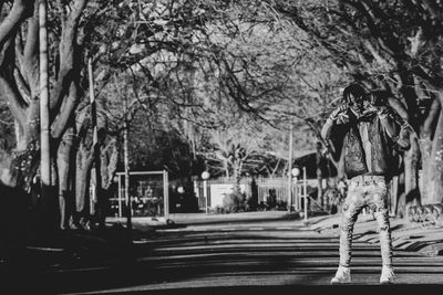 Rear view of people walking on road in city