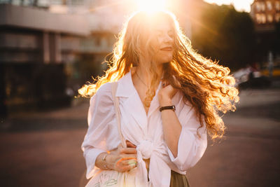 Young woman standing on street in city