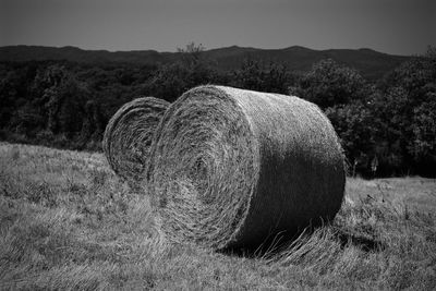 Hay bales on field against sky