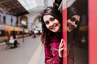 Portrait of smiling woman standing in subway train