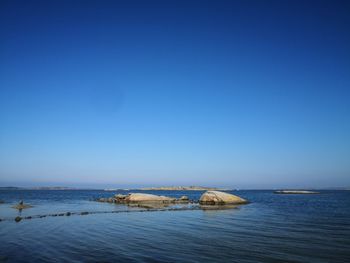 Scenic view of sea against clear blue sky