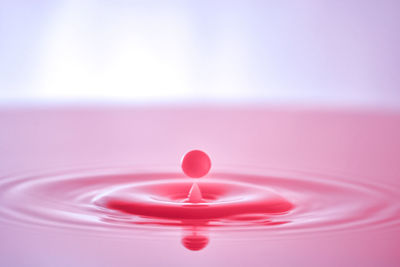 Close-up of heart shape over pink water