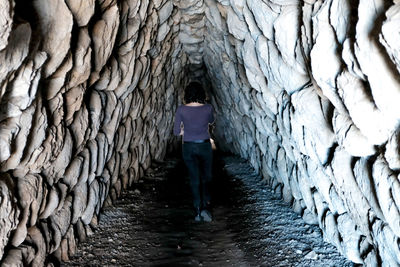 Rear view of woman standing in tunnel