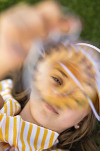 Girl wearing sun visor looking through object