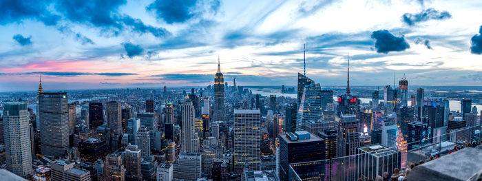 Aerial view of city buildings against cloudy sky