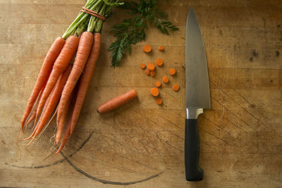 High angle view of carrots and knife on cutting board