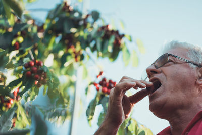 Low angle view of man with sunglasses against sky