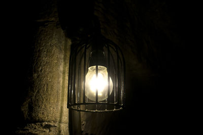 Close-up of illuminated light bulb against black background