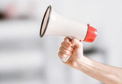 Cropped hand holding megaphone