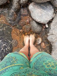 Low section of woman standing on rock