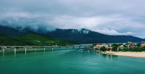 Scenic view of river and mountains against cloudy sky