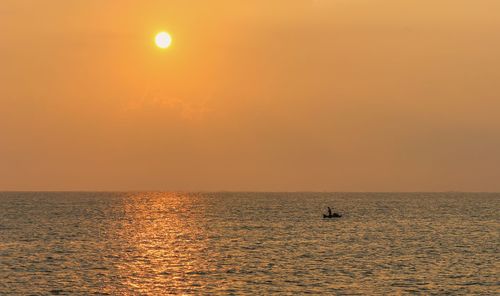 Scenic view of sea against orange sky