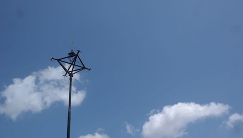 Low angle view of telephone pole against blue sky