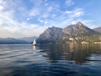 Scenic view of sea by mountains against sky
