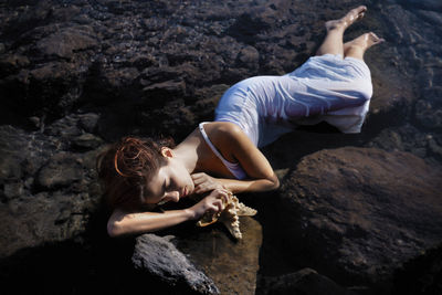 Portrait of a woman in a white dress lying in the sea