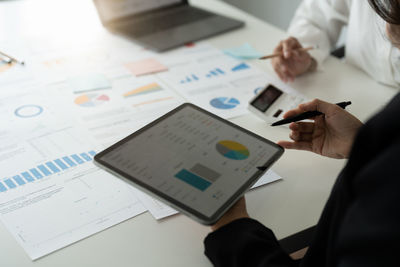 Midsection of businessman working on table