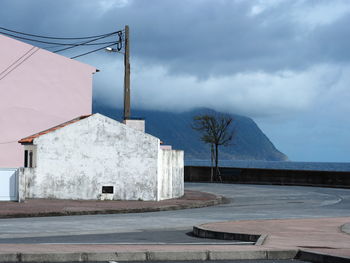 Built structure by mountain against sky