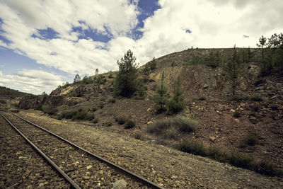 Railroad track amidst mountains against sky