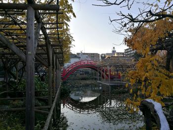 Bridge over river in city against sky