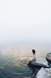 Full length of woman with arms raised against sky