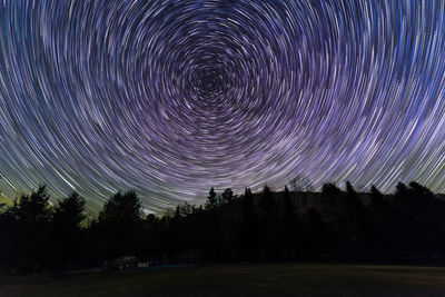Scenic view of trees against sky at night