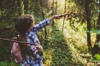 Girl holding sticks at forest