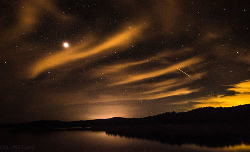 Scenic view of lake against sky at night