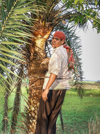 Man standing by tree on field