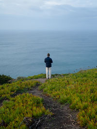 Man tourist standing on the edge of inspiring beautiful rock using mobile taking photo enjoying 