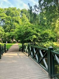 Empty footbridge along plants and trees