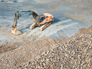 Heavy machinery in clinkstone or phonolite mining quarry. excavator with belt conveyor puts crushing