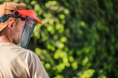 Rear view of man wearing helmet against tree