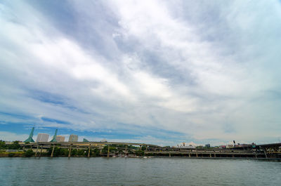 Bridge over willamette river against cloudy sky