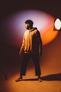 Rear view of man standing against sky during sunset